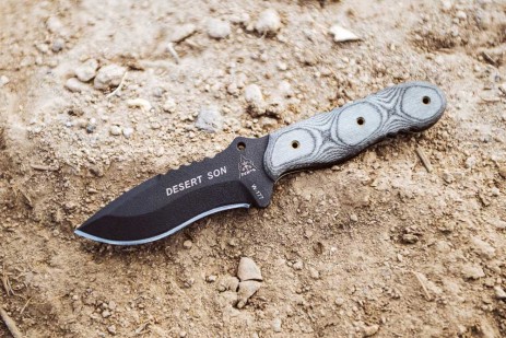 TOPS Desert Son compact fixed blade knife featuring a black recurve blade with jimping and a layered, light-toned ergonomic Black Linen Micarta handle.