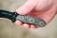 TOPS Desert Son compact fixed blade knife featuring a black recurve blade with jimping and a layered, light-toned ergonomic Black Linen Micarta handle.