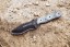 TOPS Desert Son compact fixed blade knife featuring a black recurve blade with jimping and a layered, light-toned ergonomic Black Linen Micarta handle.